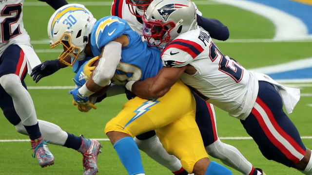 New England Patriots safety Adrian Phillips (21) tackles Los Angeles Chargers RB Austin Ekeler (30) at SoFi Stadium.